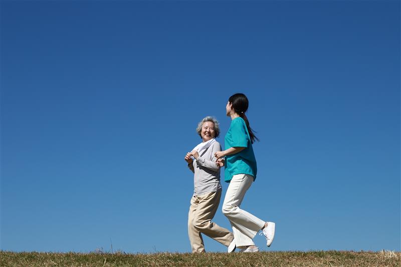 Two women walking with blue sky background