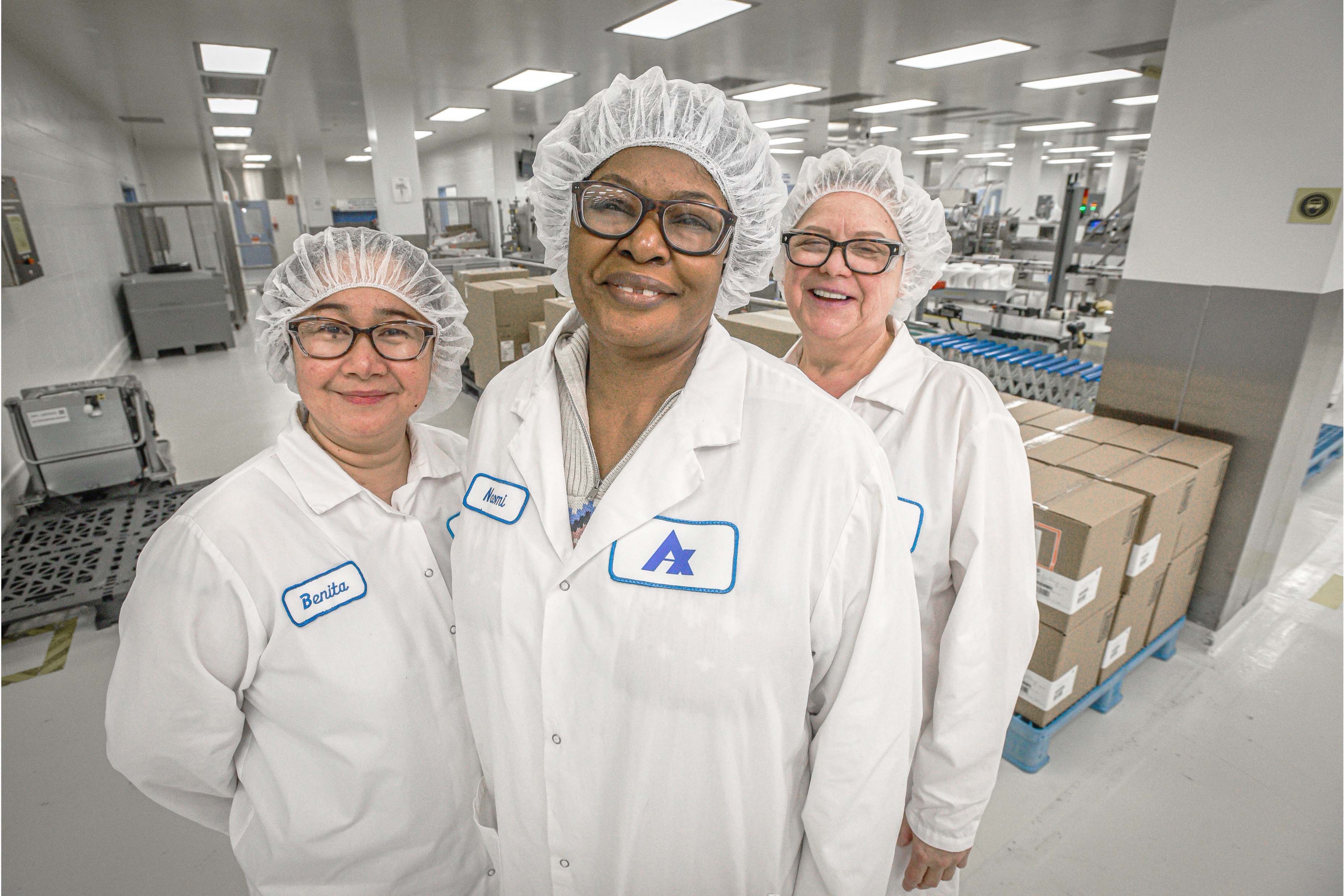Three Apotex Employees in lab coats smiling