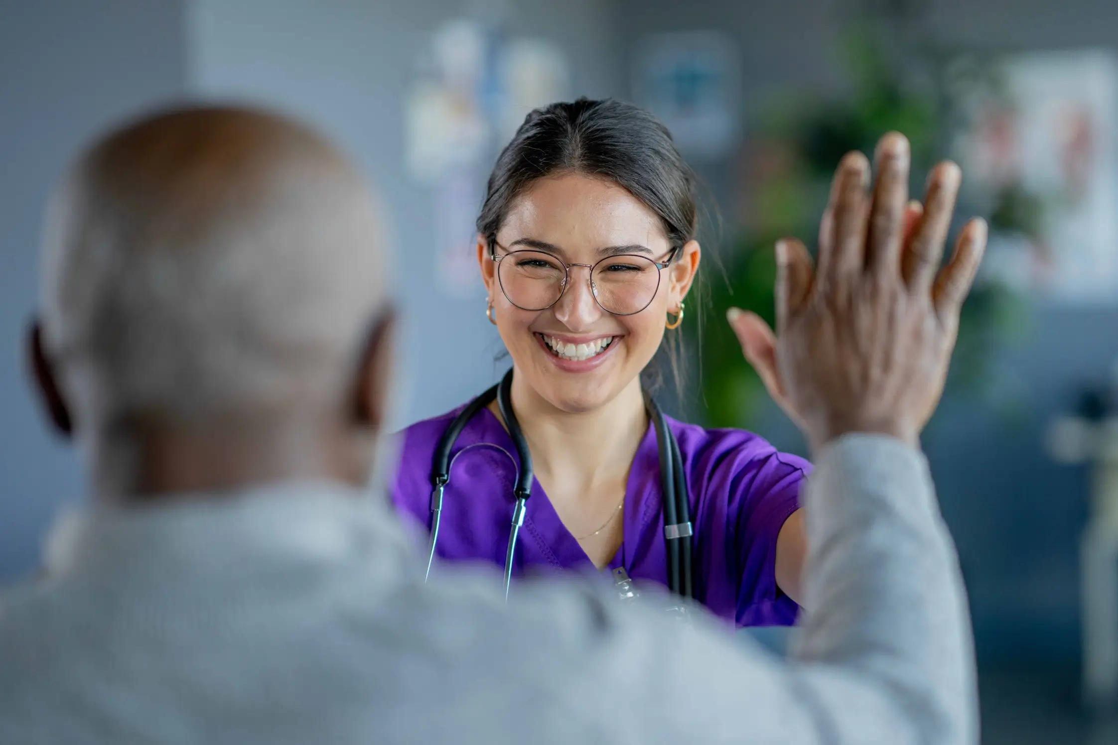 Un prestataire de soins de santé souriant et faisant un high-five à une autre personne
