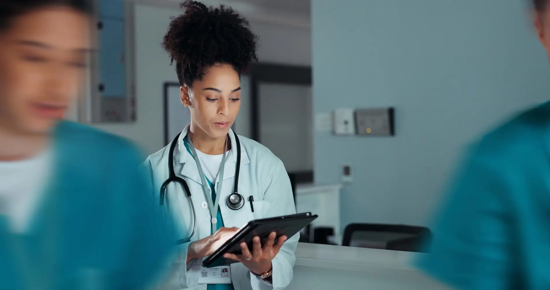 Female doctor in a lab coat using a digital tablet.