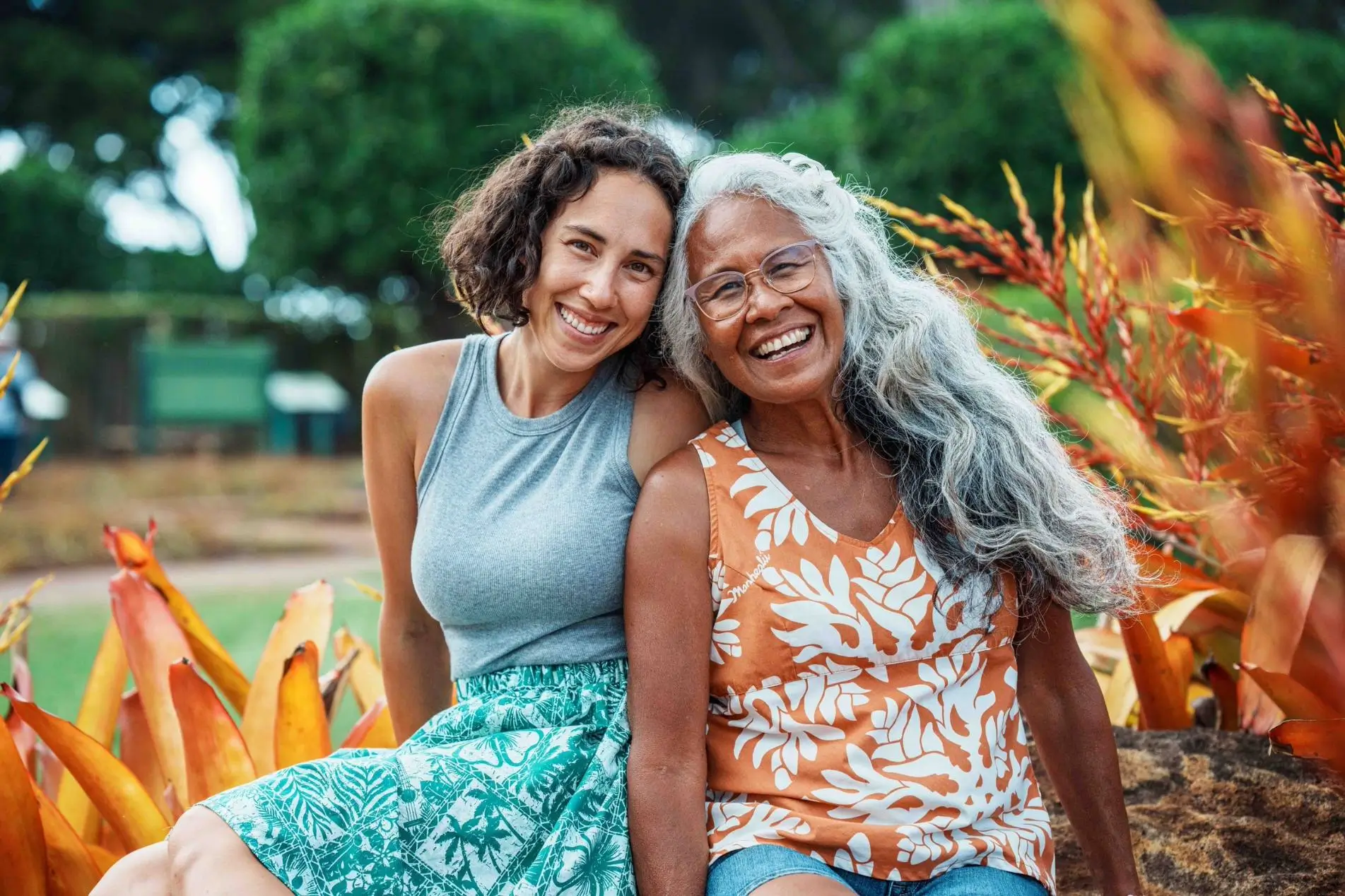 Two smiling women outdoors.